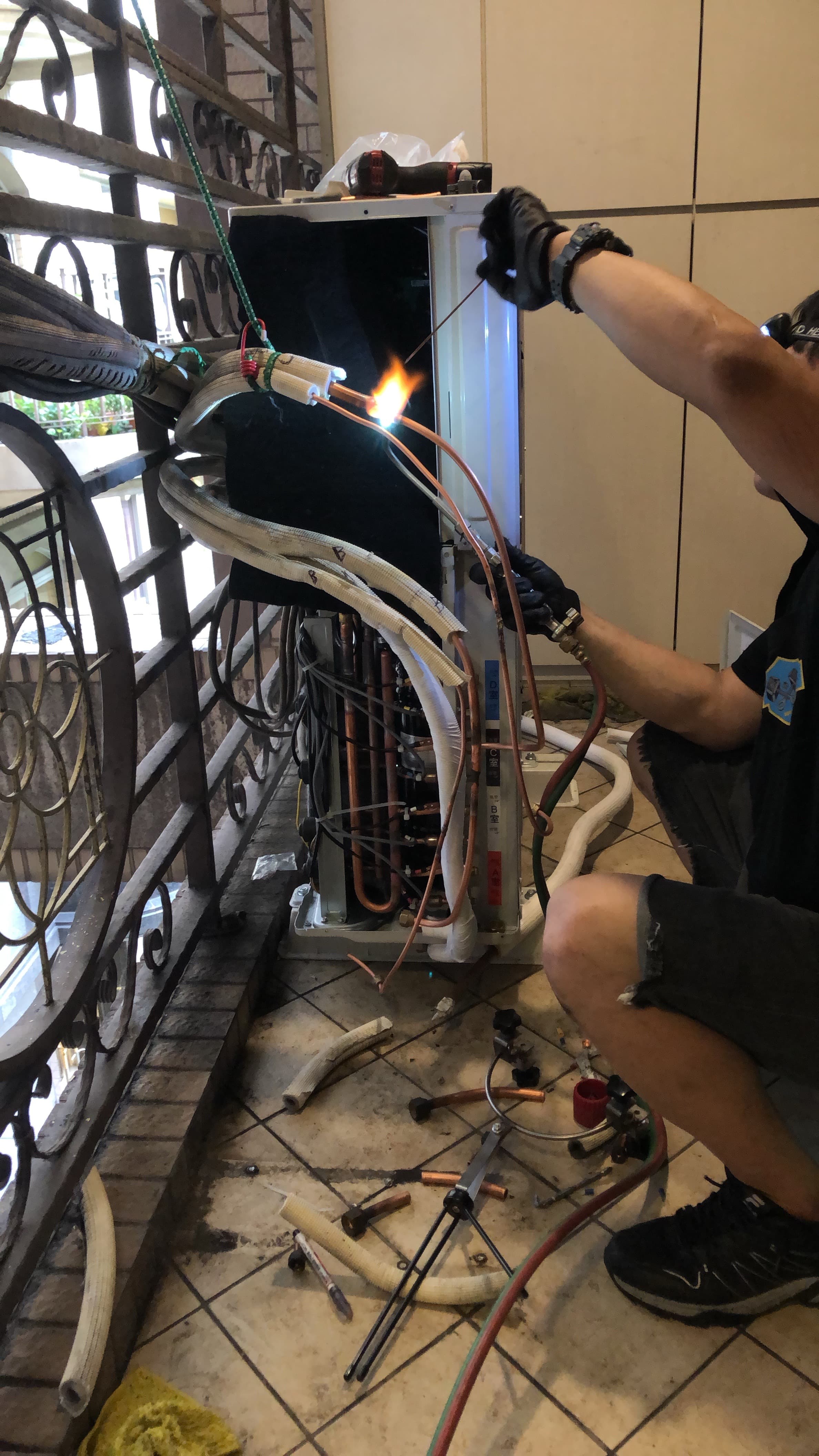 技師使用焊槍進行銅管焊接與冷媒管路修復